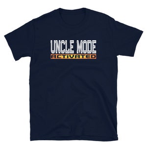 May include: A navy blue t-shirt with white text that reads "Uncle Mode Activated" in a retro video game style font.