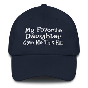 May include: A navy blue baseball cap with white embroidered text that reads "My Favourite Daughter Gave Me This Hat".