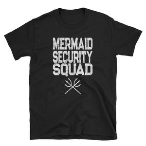 以下が含まれることがあります： 黒いTシャツに白い文字で「マーメイドセキュリティスクワッド」と、交差した2本のトライデントのグラフィックが描かれています。