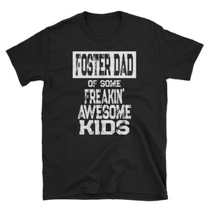 May include: Black t-shirt with white text that reads "Foster Dad of Some Freakin' Awesome Kids".