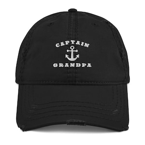 May include: Black distressed baseball cap with white embroidered text that reads "Captain Grandpa" and an anchor symbol.