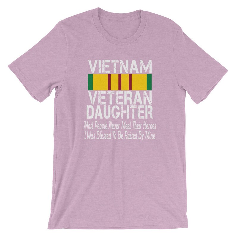 May include: A light purple t-shirt with the text "VIETNAM VETERAN DAUGHTER" and a military ribbon. The text below the ribbon reads "Most People Never Meet Their Heroes I Was Blessed To Be Raised By Mine."
