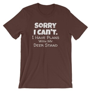 May include: Brown t-shirt with white text that reads "Sorry I can't. I have plans with my deer stand."