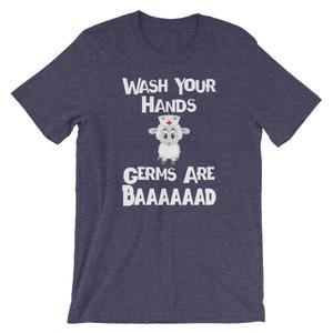 May include: A navy blue t-shirt with a white graphic of a sheep wearing a nurse's hat. The text "WASH YOUR HANDS GERMS ARE BAAAAAAAAD" is printed on the shirt.