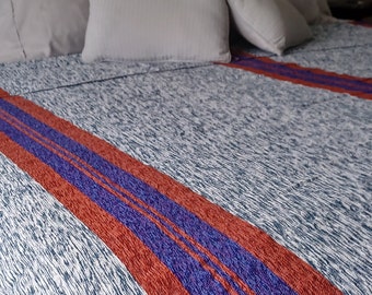 Veludo e veludo tunisiano artesanal tradicional em tons de verde-azulado escuro e roxo-terra.