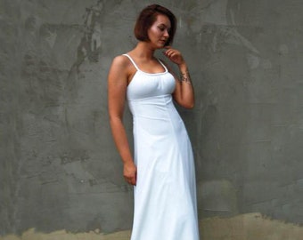 May include: A white maxi dress with thin straps. The dress has a simple, elegant design and is made of a soft, flowing fabric.