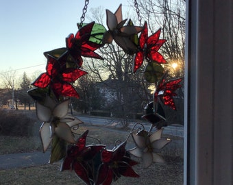 Red and white poinsettia wreath handcrafted stained glass suncatcher.