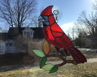 Cardinal on branch with leaves, handcrafted stained glass suncatcher.