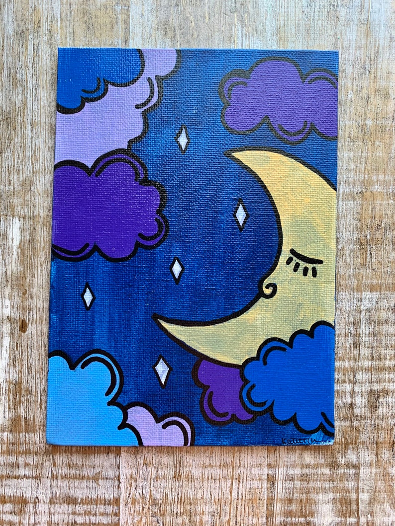 May include: A hand-painted canvas featuring a crescent moon with a sleeping face, surrounded by purple, blue, and light blue clouds against a dark blue background. The moon is yellow with a black outline and the clouds have black outlines. There are white diamond-shaped stars scattered across the canvas.