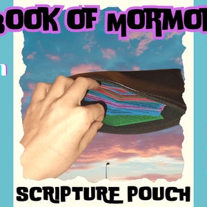 May include: A brown leather pouch with a zipper opening, revealing colorful index cards with text. The pouch is labeled "Scripture Pouch" and "Color Coded Emotions" on the sides. The pouch is open against a background of a cloudy sky.