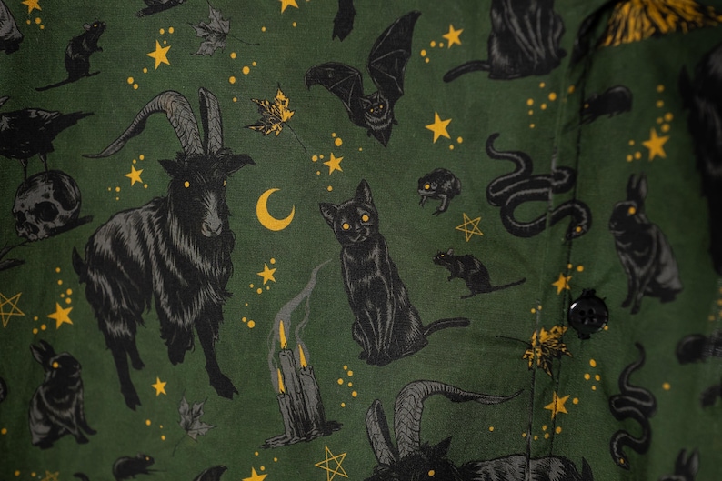 Puede incluir: Tela verde oscuro con un patr&oacute;n repetido de cabras, gatos, murci&eacute;lagos, serpientes, ratas, conejos, estrellas, lunas y velas negras. El dise&ntilde;o tiene un tema espeluznante de Halloween.