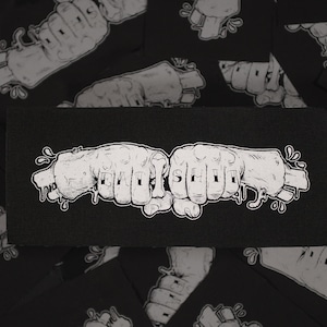 Pode incluir: Patch retangular preto com dois punhos brancos estilizados a bater. A palavra "EAT SHIT" está escrita em letras brancas nas juntas. O design inclui detalhes de tinta pingando, sobre um fundo preto.