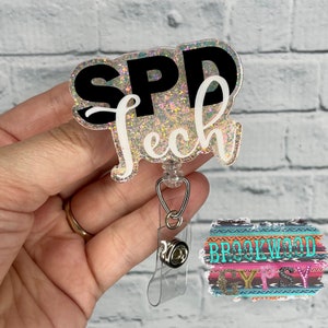 May include: A clear glitter badge holder with a black and white design that says "SPD Tech". The badge holder is attached to a retractable badge reel.