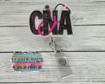 May include: A clear glitter badge holder with a black and pink "CNA" design and a stethoscope. The badge holder has a retractable cord and a clear plastic clip. The background is a wood grain pattern.