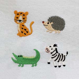 May include: Embroidered animal designs on a white fabric background. The animals include a cheetah, a hedgehog, a crocodile, and a zebra.