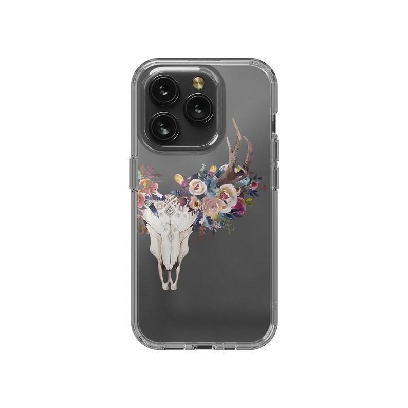 May include: A clear phone case with a floral design. The design features a white skull with antlers and a floral wreath around the skull. The flowers are in shades of pink, blue, and purple.