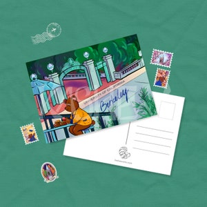 May include: A postcard featuring a cartoon illustration of a bear sitting at a table outside the University of California, Berkeley. The postcard has a blank space on the back for writing a message.