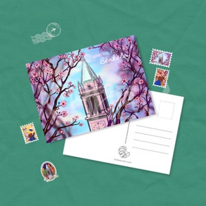 May include: A postcard featuring a colorful illustration of a tower framed by blooming cherry blossoms. The text "Spring Bloom Berkeley" is visible. Several decorative stamps and a blank postcard back are also present.