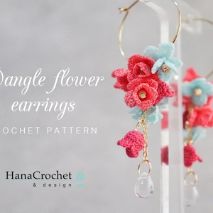 May include: Crochet dangle flower earrings with pink and blue flowers and a crystal charm. The earrings are on a gold hoop and a gold chain. The text "Dangle flower earrings CROCHET PATTERN HanaCrochet & design" is on the image.