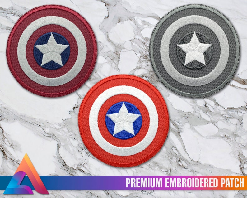 May include: Three embroidered patches featuring the iconic Captain America shield design. The patches are red, white, and blue, gray, and white, and black, white, and gray. Each patch features a white star in the center.