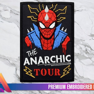 May include: Embroidered patch featuring a red and blue cartoon Spider-Man with a punk rock aesthetic. The patch has the text "The Anarchic Tour" in white lettering.