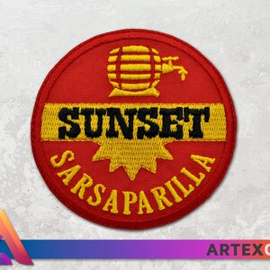 Op de afbeelding: Rode, gele en zwarte geborduurde patch met de woorden "Sunset Sarsaparilla" en een gestileerd beeld van een vat met een kraan.