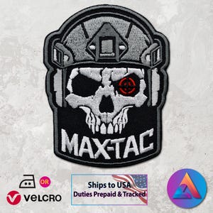 May include: Embroidered patch with a skull design wearing a tactical helmet. The skull has a red target in one eye and the text "MAX-TAC" below. The patch is black, white, and grey.