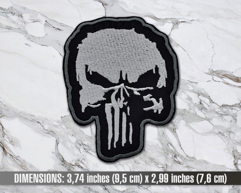 May include: A black and white embroidered patch of the Punisher skull. The skull is 3.74 inches (9.5 cm) wide and 2.99 inches (7.6 cm) tall.