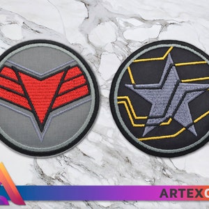 Könnte beinhalten: Zwei gestickte Patches, einer mit einem roten und grauen Sternburst-Design und der andere mit einem grauen Stern auf schwarzem Hintergrund mit gelben Linien.