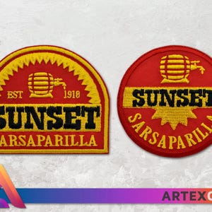 Op de afbeelding: Twee geborduurde patches met een rode achtergrond en gele accenten. De patches tonen de tekst "Sunset Sarsaparilla" en een gestileerde afbeelding van een vat met een kraan. De tekst "Est. 1918" is ook op een van de patches te zien.