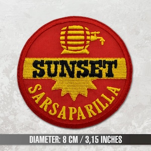 Op de afbeelding: Rode, gele en zwarte geborduurde patch met de tekst "Sunset Sarsaparilla" en een gestileerd beeld van een vat met een kraan.