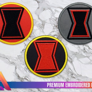 May include: Three embroidered patches featuring the Black Widow symbol. The patches are circular and have a yellow border. The symbol is red on a black background in one patch, black on a red background in another, and black on a gray background in the third.