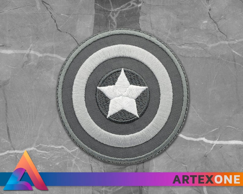 May include: A gray embroidered patch with a white star in the center, surrounded by a white circle and a gray outer circle.