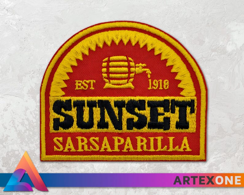 Op de afbeelding: Een geborduurde patch in rood, geel en zwart met de tekst "EST. 1918 SUNSET SARSAPARILLA" en een gestileerd beeld van een vat met een kraan.
