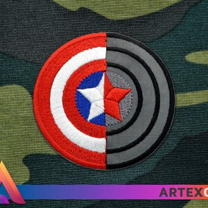 Puede incluir: Un parche bordado rojo, blanco y azul con una estrella en el centro, la mitad de la cual est&aacute; cubierta por un parche bordado gris con c&iacute;rculos conc&eacute;ntricos.