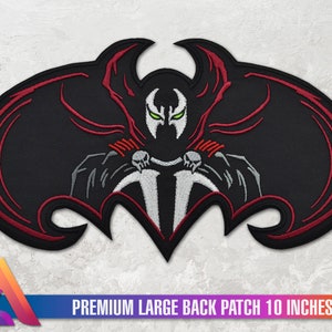 Könnte beinhalten: Ein gestickter Patch in Schwarz und Rot mit einem Superhelden-Charakter mit einem Schädel und Flügeln. Der Patch ist 25,4 cm breit und trägt die Aufschrift "PREMIUM LARGE BACK PATCH 10 INCHES WIDE".