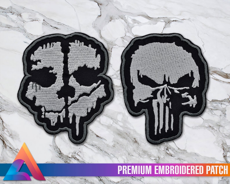 May include: Two embroidered patches, one with a white skull with dripping paint and the other with a white skull with a skull and crossbones design. Both patches are on a white marble background.