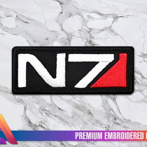 May include: Black embroidered patch with white "N7" lettering and a red triangle. The patch is labelled "Premium Embroidered Patch".