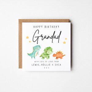 May include: Happy Birthday Grandad card with three cartoon dinosaurs, a blue, a green, and an orange dinosaur. The card has gold stars and the text "With lots of love from Lewis, Hollie & Jack xxx".