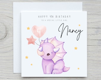 May include: A white card with a purple dinosaur holding pink balloons with the number 4 on them. The card says "Happy 4th Birthday to a special little girl" and "Nancy".