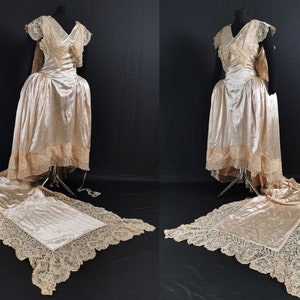 Könnte beinhalten: Ein Vintage-Hochzeitskleid mit langem Schleier und Spitzendetails. Das Kleid ist aus einem weichen, fließenden Stoff gefertigt und hat ein tailliertes Oberteil. Der Schleier ist aus zarter Spitze gefertigt und sehr lang.