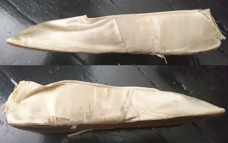May include: A pair of off-white satin ballet slippers with frayed edges and a pointed toe.