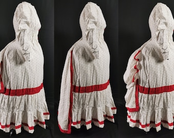May include: A white dress with a red trim and a small floral pattern. The dress has a long, flowing skirt and a fitted bodice. The dress is designed with a hood and long sleeves.