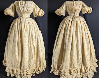 May include: A yellow dress with a red and white pattern. The dress has a fitted bodice and a full skirt. The skirt has a ruffle at the hem.