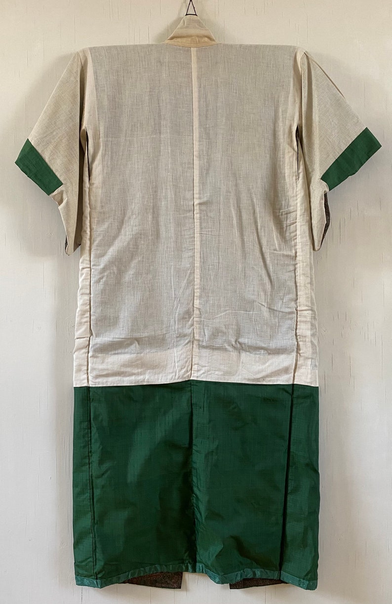 May include: A white and green Japanese kimono with a long, flowing design. The kimono has a white top and a green bottom. The kimono is made of a soft, lightweight fabric.
