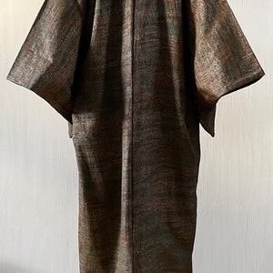 May include: A long, brown and green patterned kimono with a traditional Japanese design. The kimono is made of a soft, flowing fabric and has a relaxed fit.