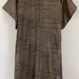 May include: A brown and green patterned kimono with short sleeves. The kimono is made of a silky fabric and has a subtle sheen.