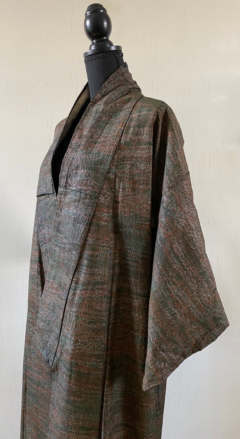 May include: A brown and green patterned kimono with a V-neck and long sleeves.