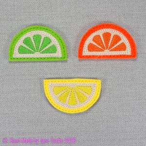 May include: Three semi-circular embroidered patches shaped like citrus slices. One patch is lime green, one is bright orange, and one is lemon yellow. Each features a white border and internal segment detailing. Text reads: Hand Made by Jane Crafts 2026.