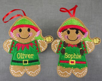 May include: Two gingerbread elf ornaments, one green and one red, with the names Oliver and Sophie embroidered on them.